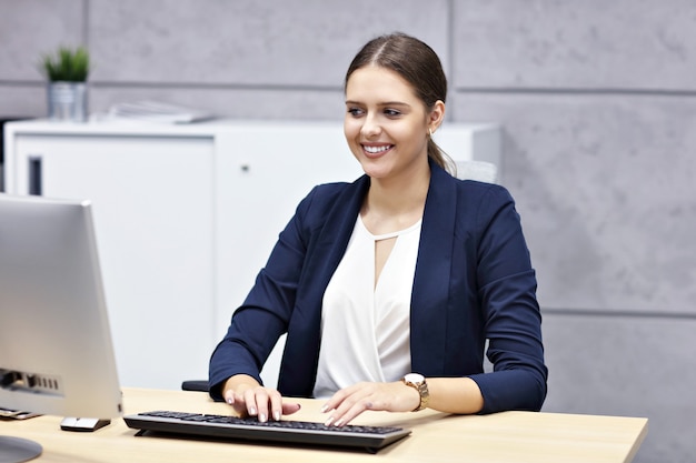 close up portrait of attractive smiling businesswoman at workplace