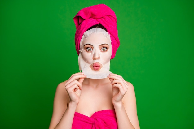 Close-up portrait of attractive stunned lady wearing turban removing facial smoothing mask therapy pout lips isolated on bright green color background