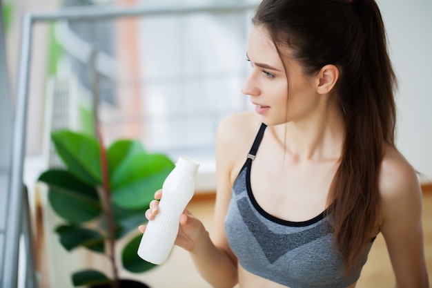 Close-up portrait of an attractive young woman drink yogurt.