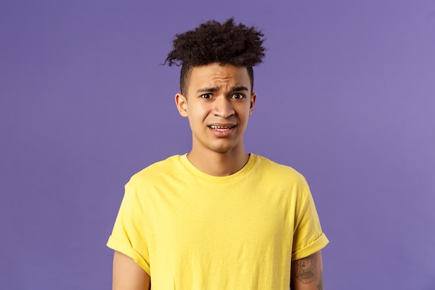 Close-up portrait of awkward and embarrassed young hispanic guy looking nervous, meeting girlfriend parents, stare scared and with panic, feeling concerned, cringe over 