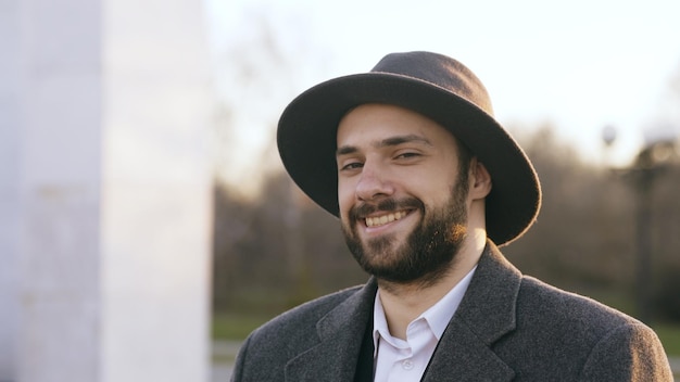 Close up portrait of bearded young hipster businessman smiling and looking into camera