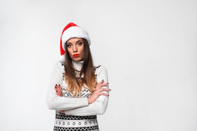 Close up portrait beautifiul caucasian woman in red Santa hat on white  wall. Christmas and New Year  concept.