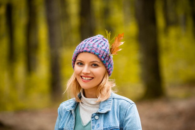 Close up portrait of beautiful blond girl on autumn background.