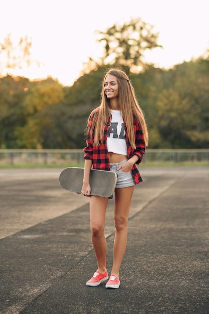 Ritratto di una bella donna adolescente carina con un corpo perfetto in camicia rossa, maglietta bianca, pantaloncini e scarpe da ginnastica rosse da vicino