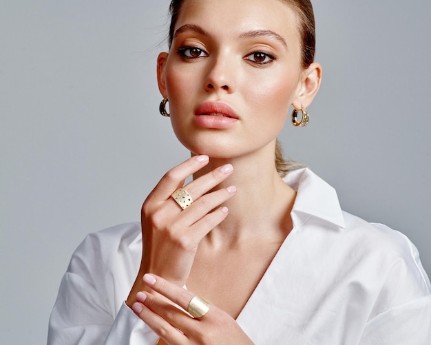 Close up portrait of a beautiful elegant woman with stylish jewelry on a white background Beautiful girl with jewelry