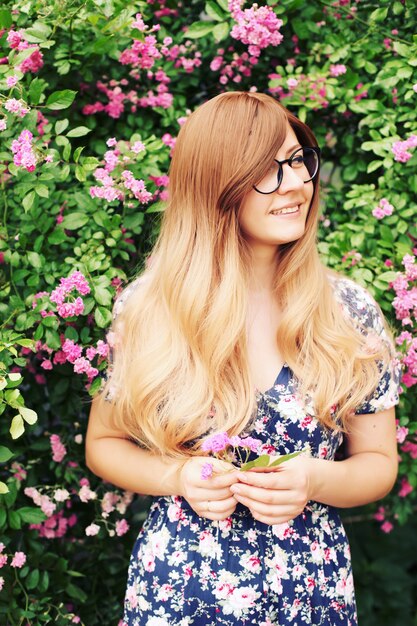 Close up portrait of a beautiful girl in roses garden