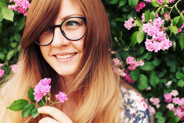 Close up portrait of a beautiful girl in roses garden