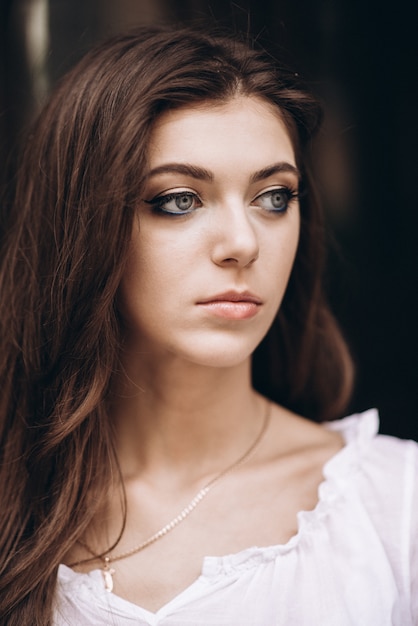 Close-up portrait of a beautiful girl in a white dress