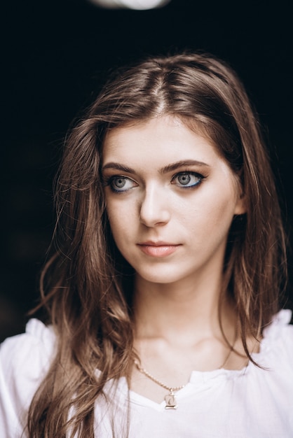 Close-up portrait of a beautiful girl in a white dress