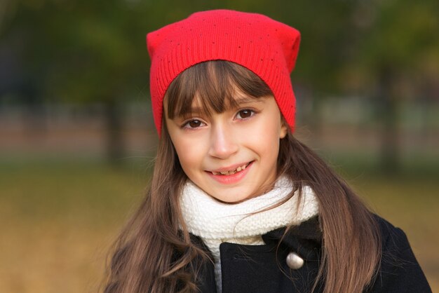 見ている前向きな子の小さな女の子の笑顔の美しい幸せなかわいい子供の肖像画をクローズアップ