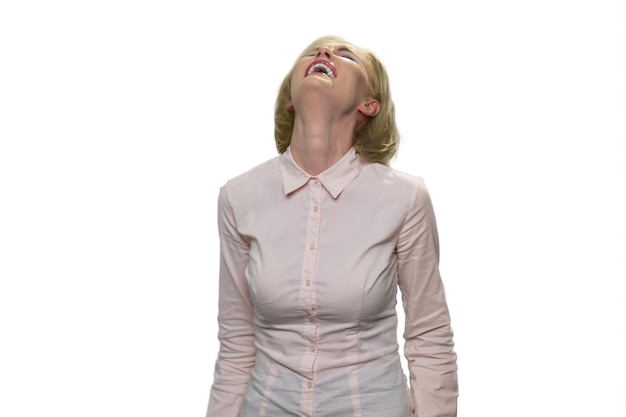 Close up portrait of a beautiful middle aged woman laughing against white wall. Mature lady wearing white formal shirt laughing out loud.