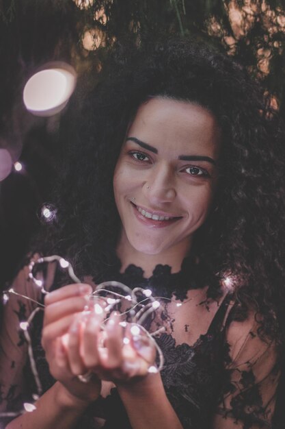 Photo close-up portrait of beautiful woman holding illuminated lights