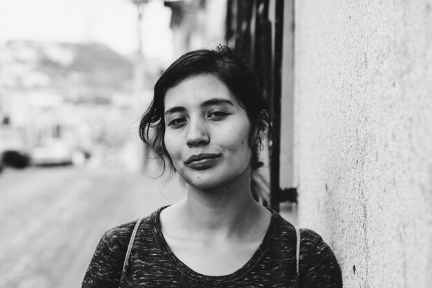 close-up portrait of beautiful woman standing by wall in city