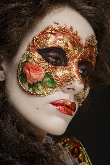 빈티지 드레스와 그의 얼굴에 마스크에서 아름 다운 여자의 클로 우즈 업 초상화.