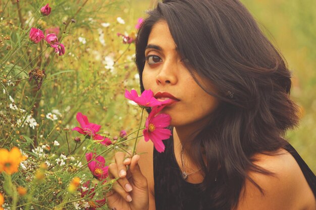 Photo close-up portrait of beautiful woman with pink flower