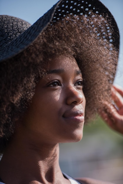 Close up portrait of a beautiful young african american woman smiling and looking up on a beautiful sunny day