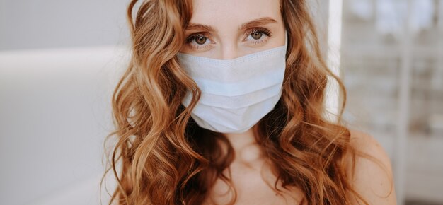 Close up portrait of beautiful young european woman wearing protective mask for corona virus prevention, hygiene to stop spreading coronavirus. Avoid contaminating Corona virus Covid-19 concept