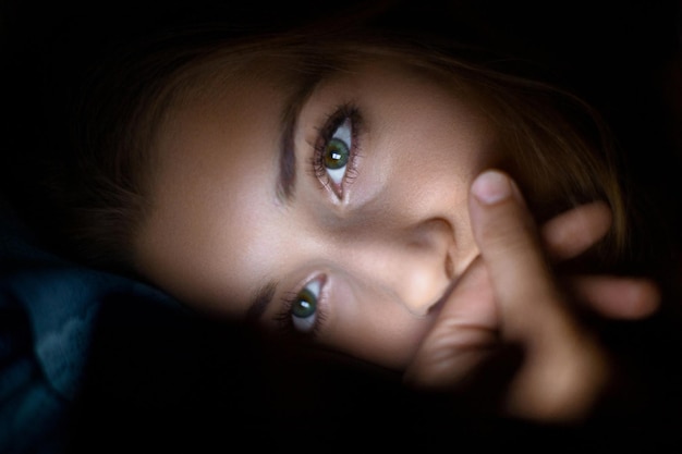 Photo close-up portrait of beautiful young woman in darkroom