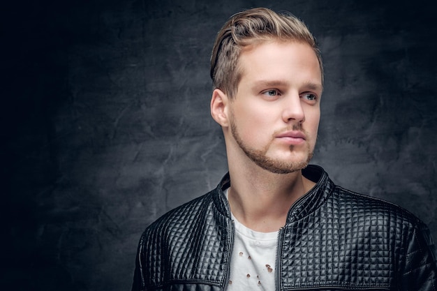 Photo close up portrait of blond bearded male dressed in a black leather jacket.