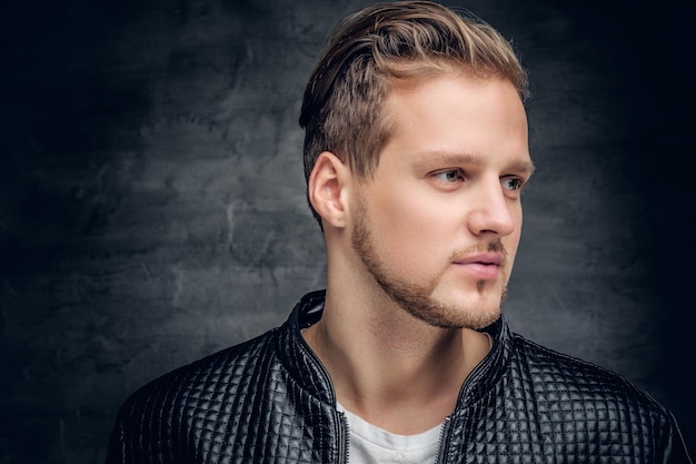 Close up portrait of blond bearded male dressed in a black leather jacket.