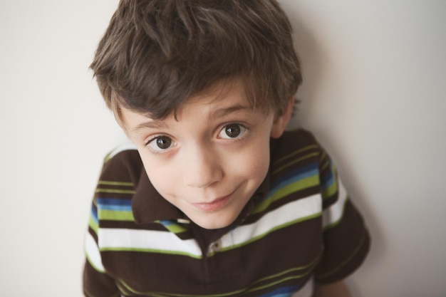 close-up portrait of boy smiling by wall