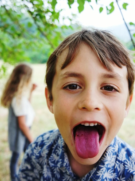 舌を突き出している男の子のクローズアップ肖像画