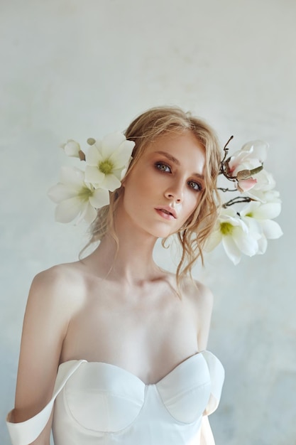 close-up portrait of bride with flowers on head against wall