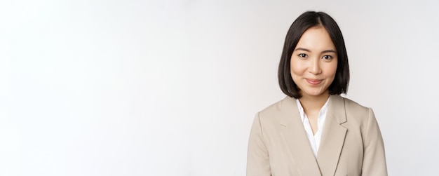 Close up portrait of businesswoman asian female entrepreneur in suit smiling and looking professional standing against white background