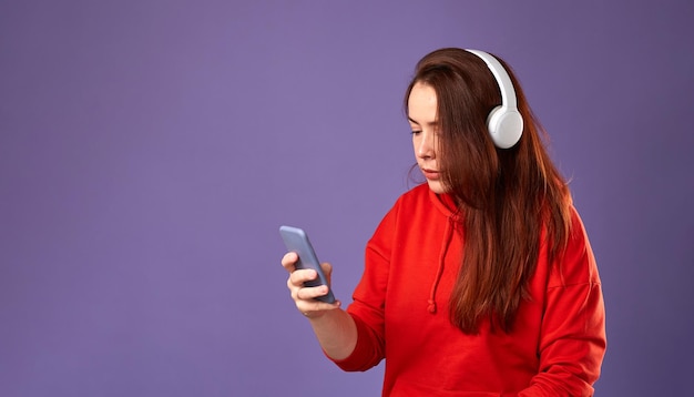 Photo close up portrait of caucasian woman podcast or music listening on purple background female listening music in headphones