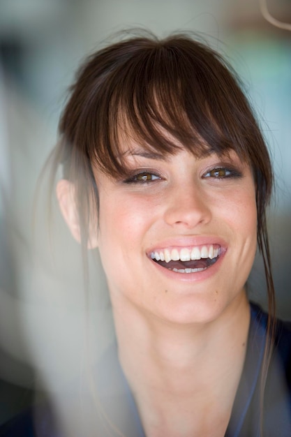 Close-up portrait of cheerful beautiful woman with bangs