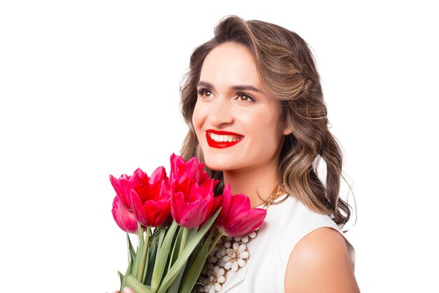 Крупным планом портрет веселой женщины, улыбающейся с букетом тюльпанов