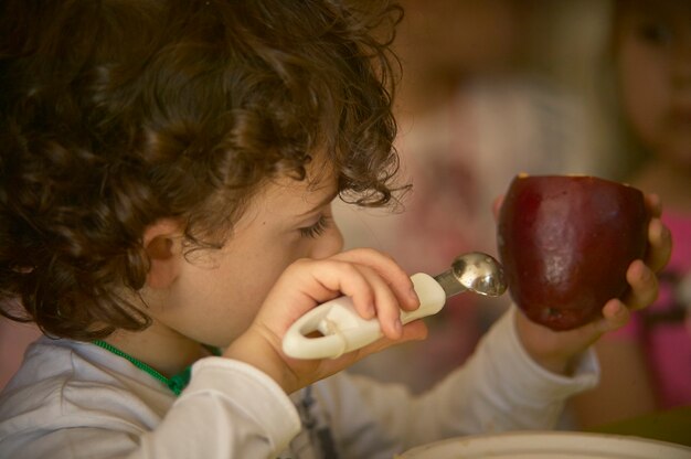 Close up ritratto di bambino ha uno spuntino sano con la mela