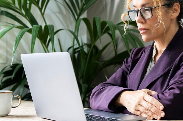 Close up portrait of confident serious business woman entrepreneur looking computer Online business job difficulties Businesswoman thinking in front of a laptop Problems and solutions at online job