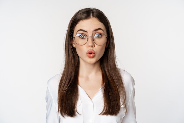 Close up portrait of corporate woman in glasses looking surprised amazed and intrigued standing over...