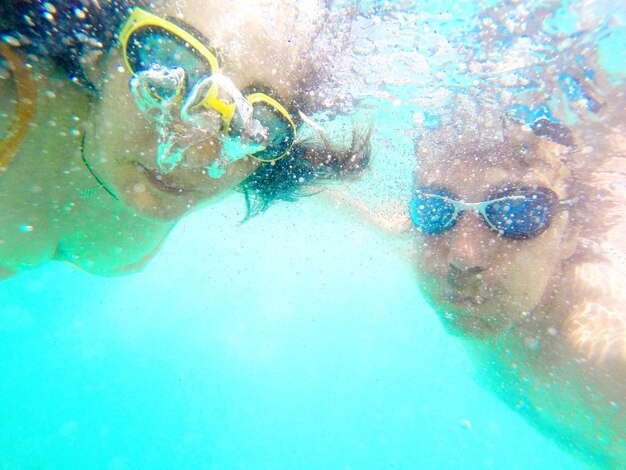 Close-up portrait of couple swimming underwater