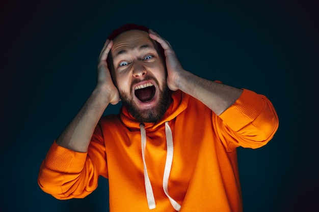 Photo close up portrait of crazy scared and shocked man isolated on dark background