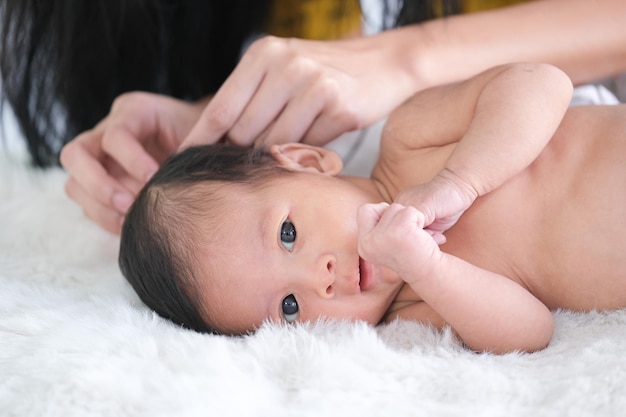 Photo close-up portrait of cute baby lying on bed at home