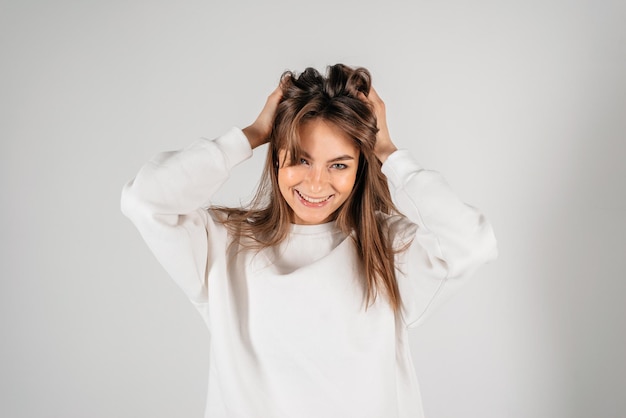 Close up portrait of cute and charming young lady looking at camera isolated on white background