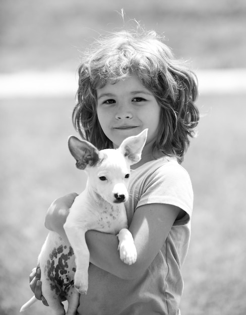 Chiuda sul ritratto del bambino sveglio che abbraccia il cane. ragazzino che abbraccia un cane.