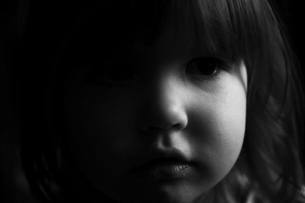 Photo close-up portrait of cute girl in darkroom