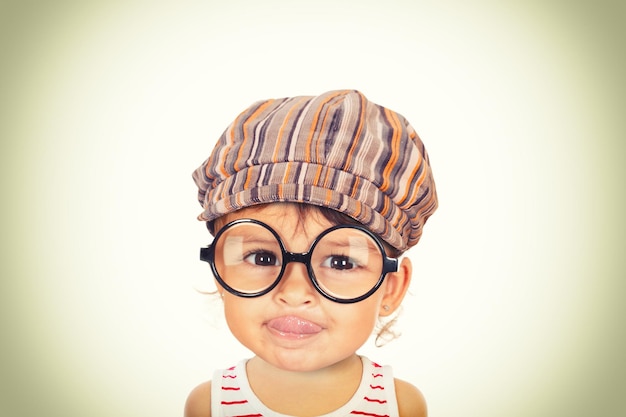 Close-up portrait of cute girl sticking out tongue against white background