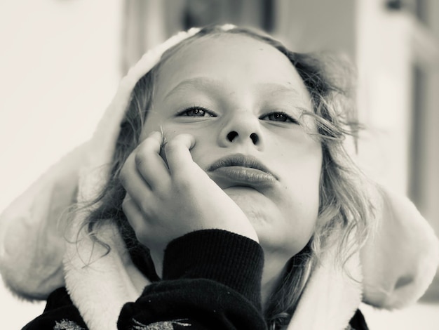 Close-up portrait of cute girl with hand on chin