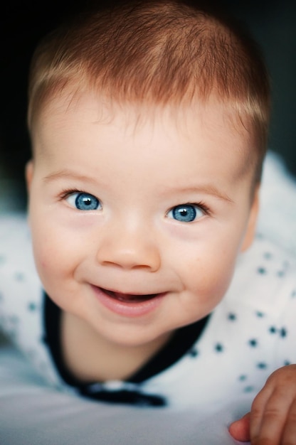 Photo close-up portrait of cute happy baby boy with blue eyes