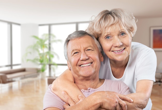 Close-up portrait of an elderly couple hugging in park