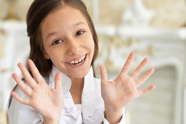 Close up portrait of emotional little girl in white blouse