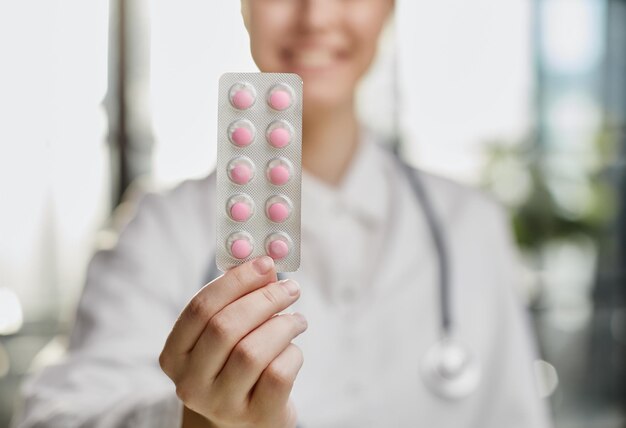 カメラを見ている女性医師科学者薬剤師が新しい有効な薬剤を紹介するクローズアップポートレート