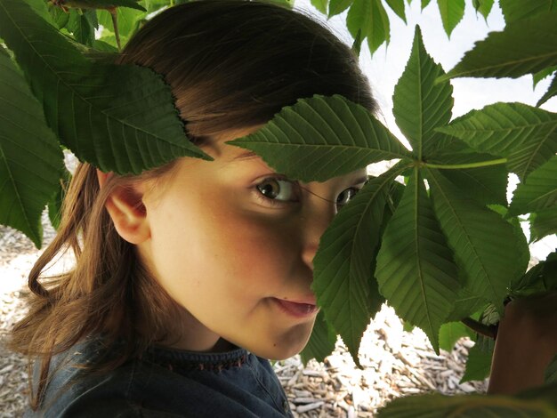 Foto ritratto in primo piano di una ragazza tra le foglie