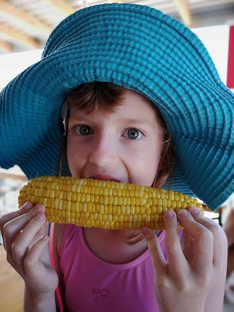 Foto ritratto in primo piano di una ragazza che mangia mais