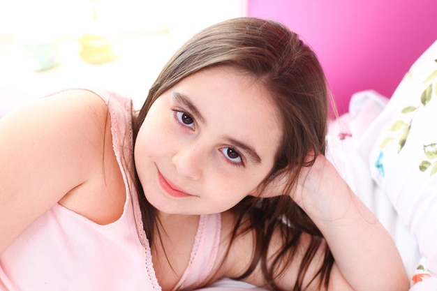 Photo close-up portrait of girl lying on bed at home