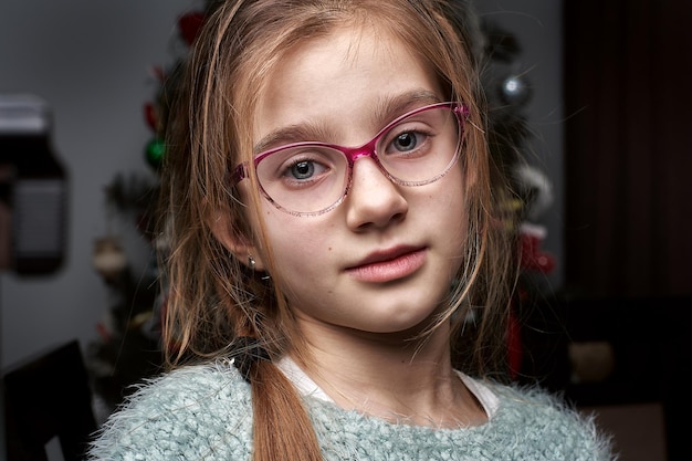 Foto ritratto in primo piano di una ragazza che indossa gli occhiali a casa